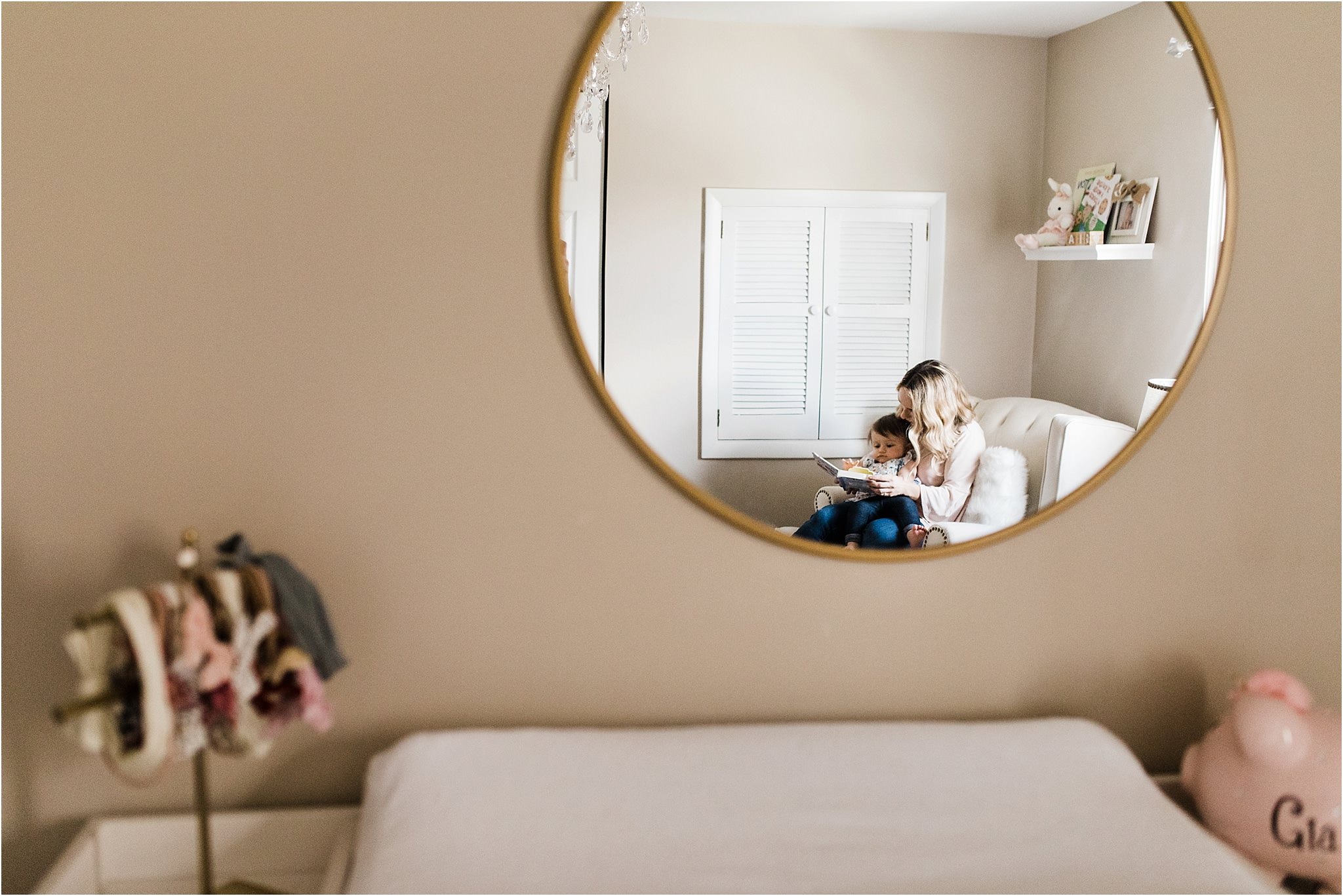 MOTHER READING TO ONE YEAR IN HER NURSERY