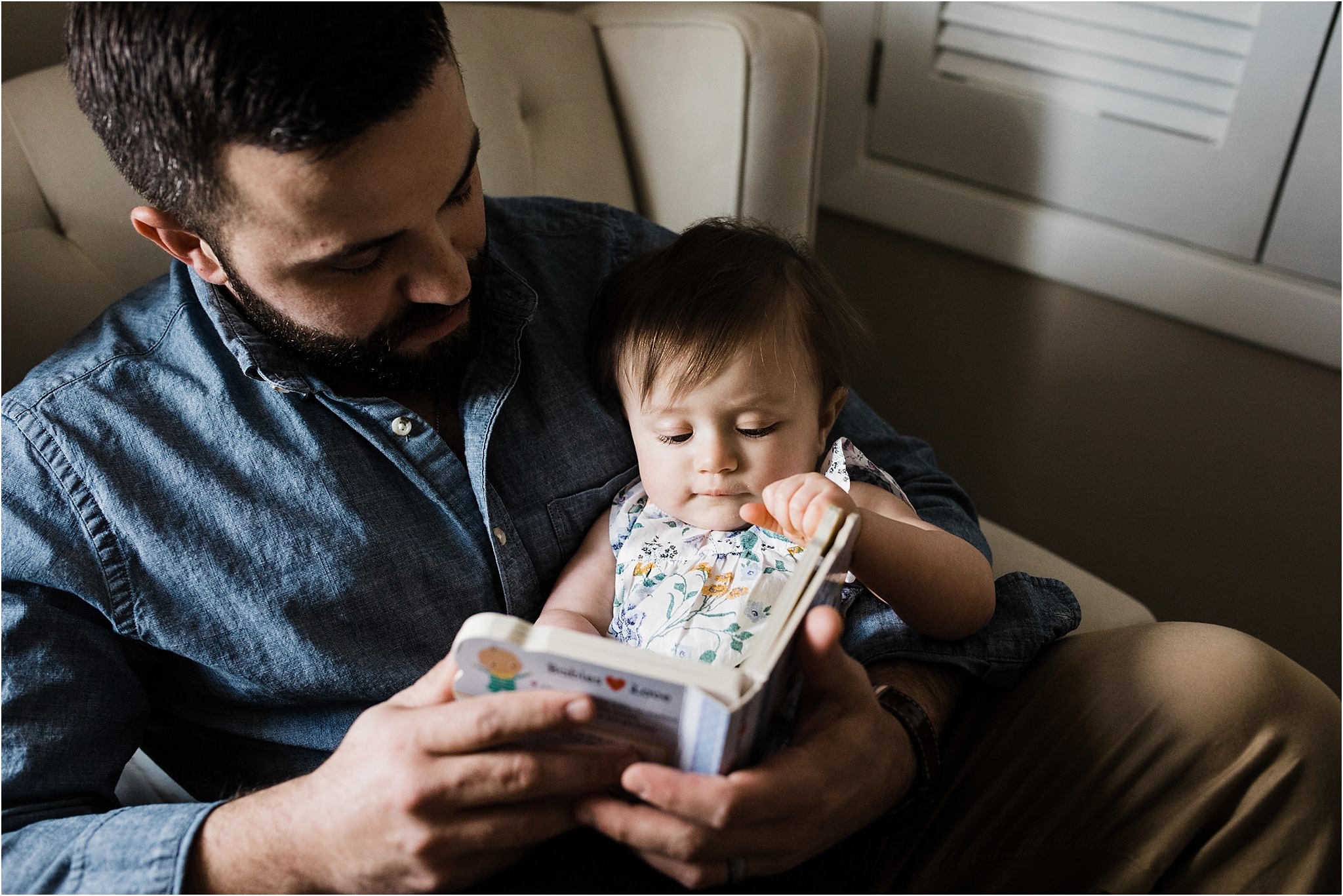 FATHER READING TO ONE YEAR IN HER NURSERY