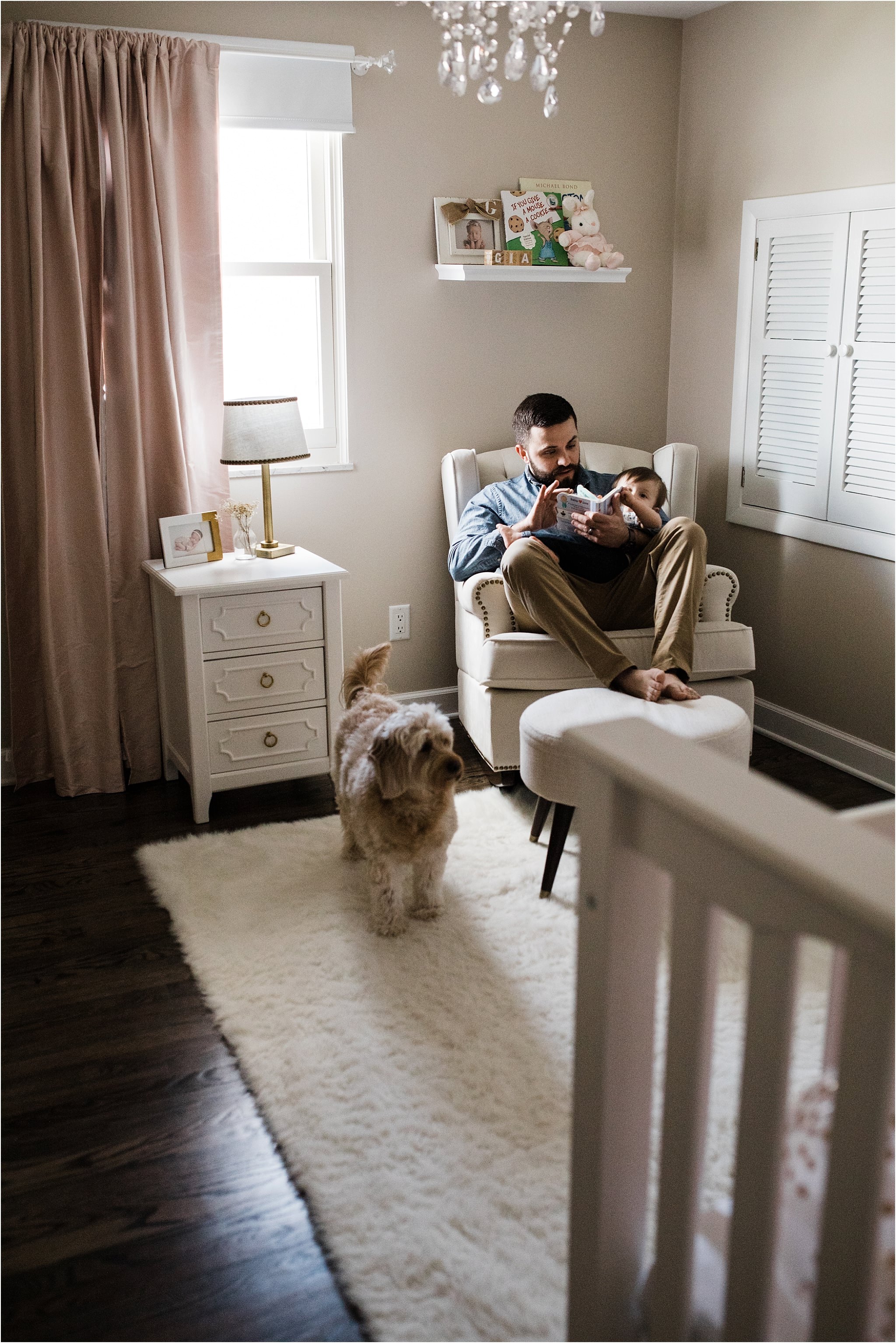 FATHER READING TO ONE YEAR IN HER NURSERY