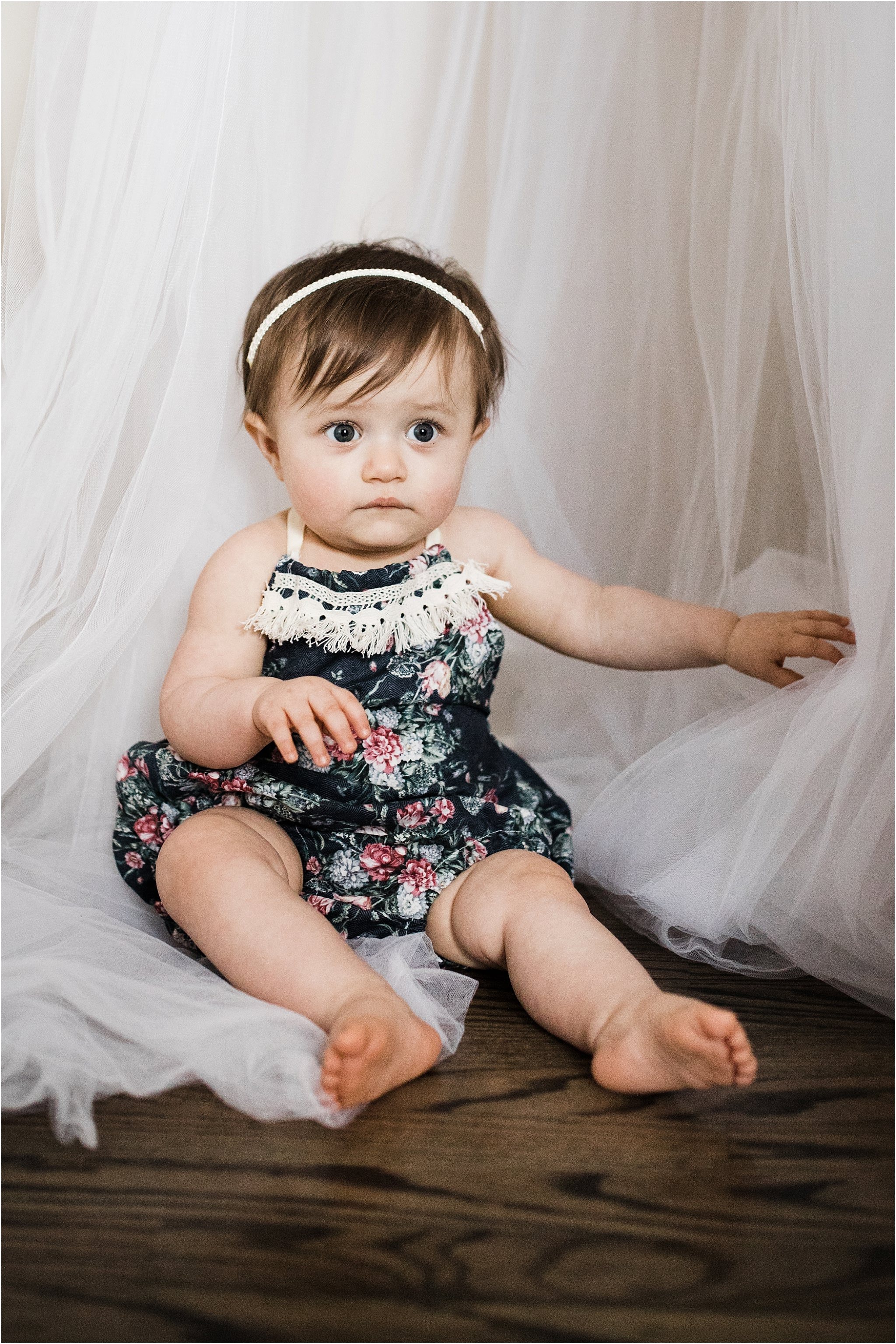 ONE YEAR OLD GIRL IN FLORAL ROMPER PHOTOS IN FEMININE NURSERY