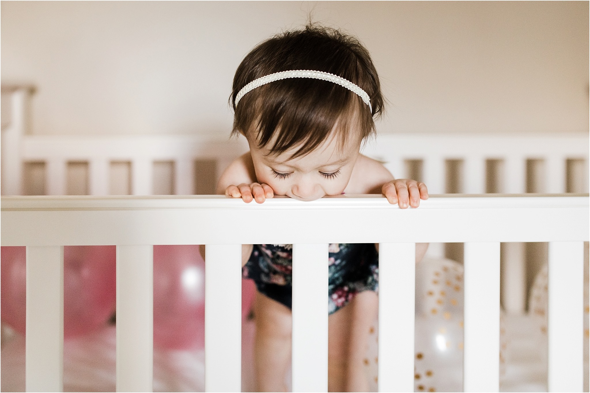 ONE YEAR OLD GIRL IN FLORAL ROMPER PHOTOS IN NURSERY