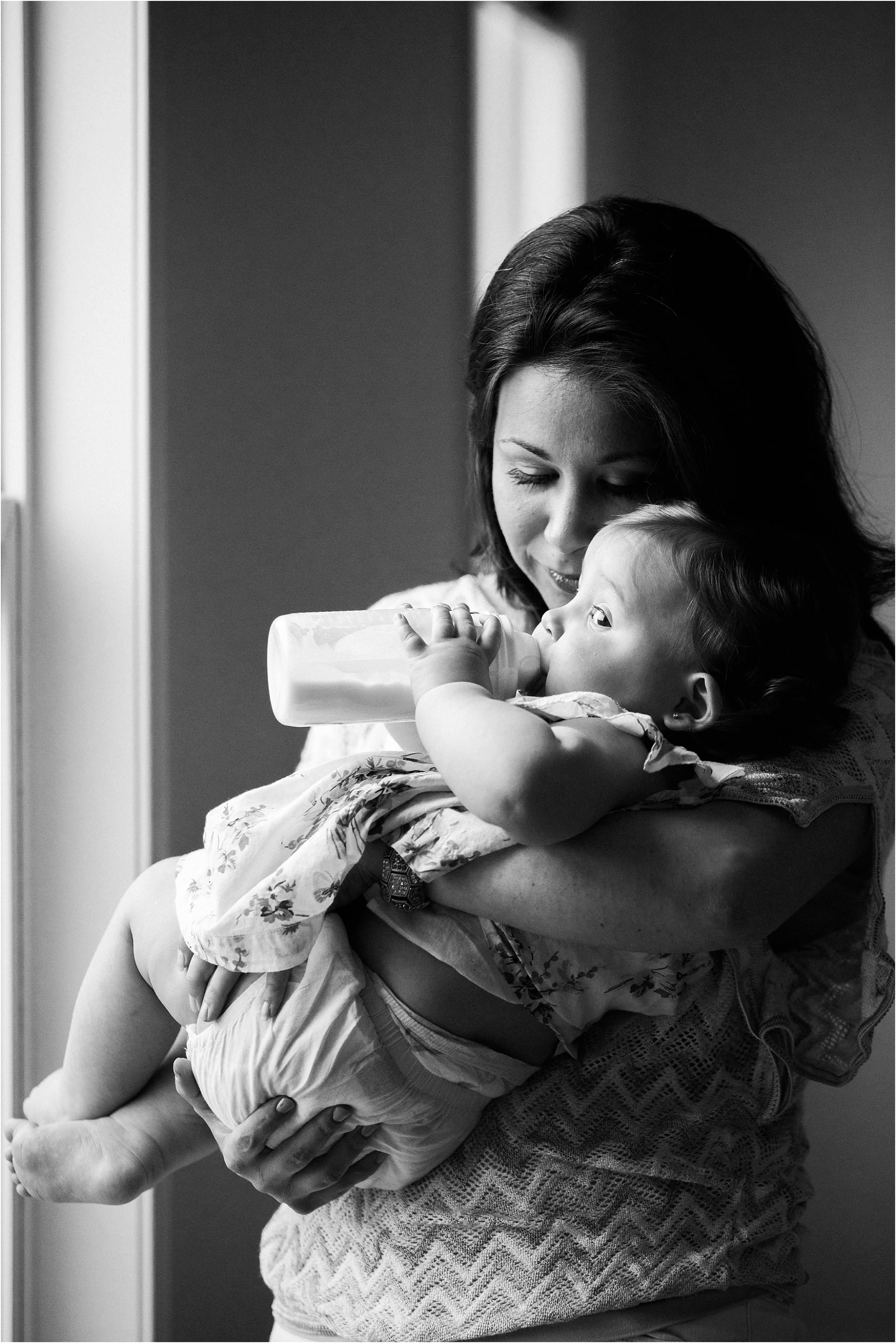 mother giving daughter a bottle