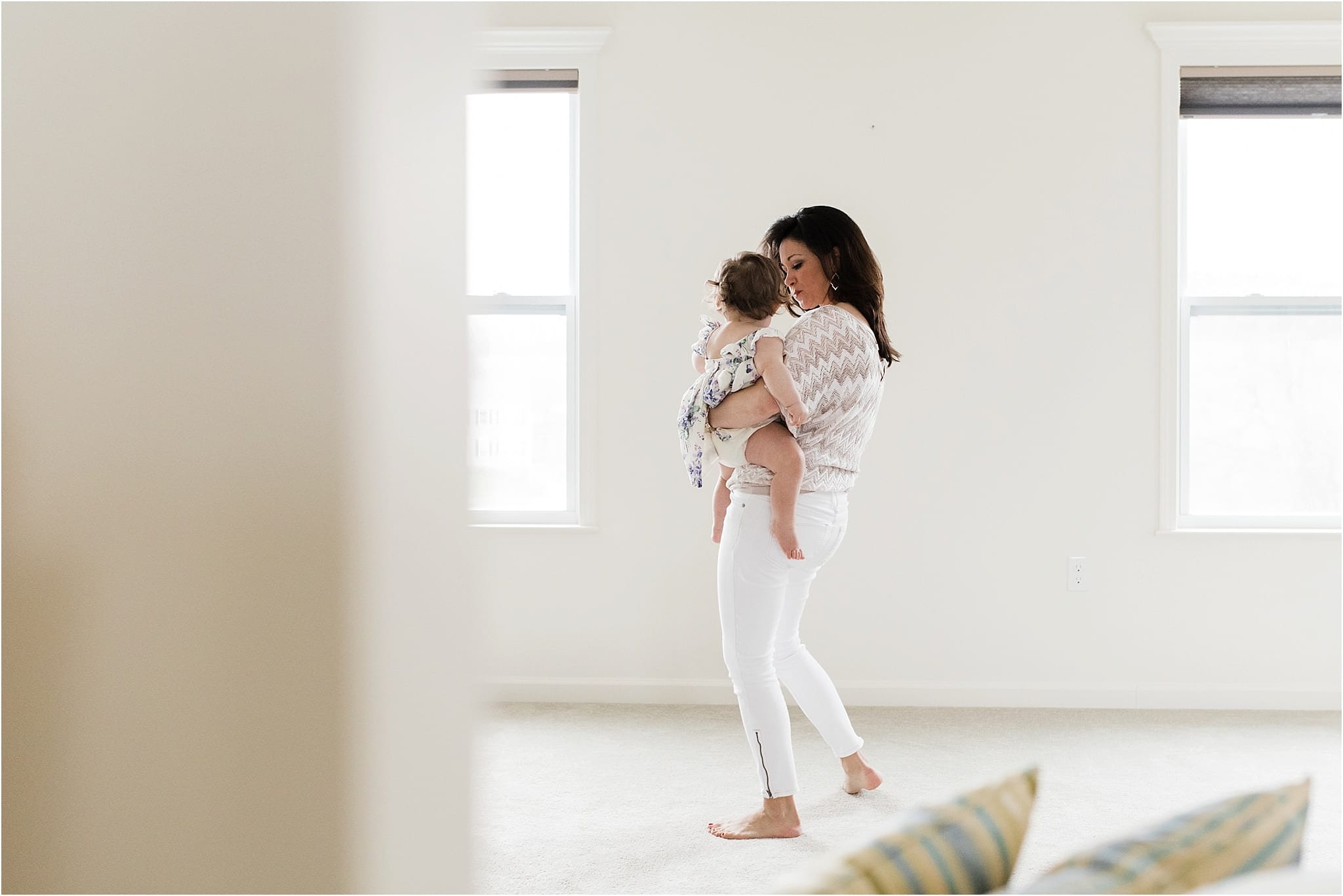 mother holding baby girl at home