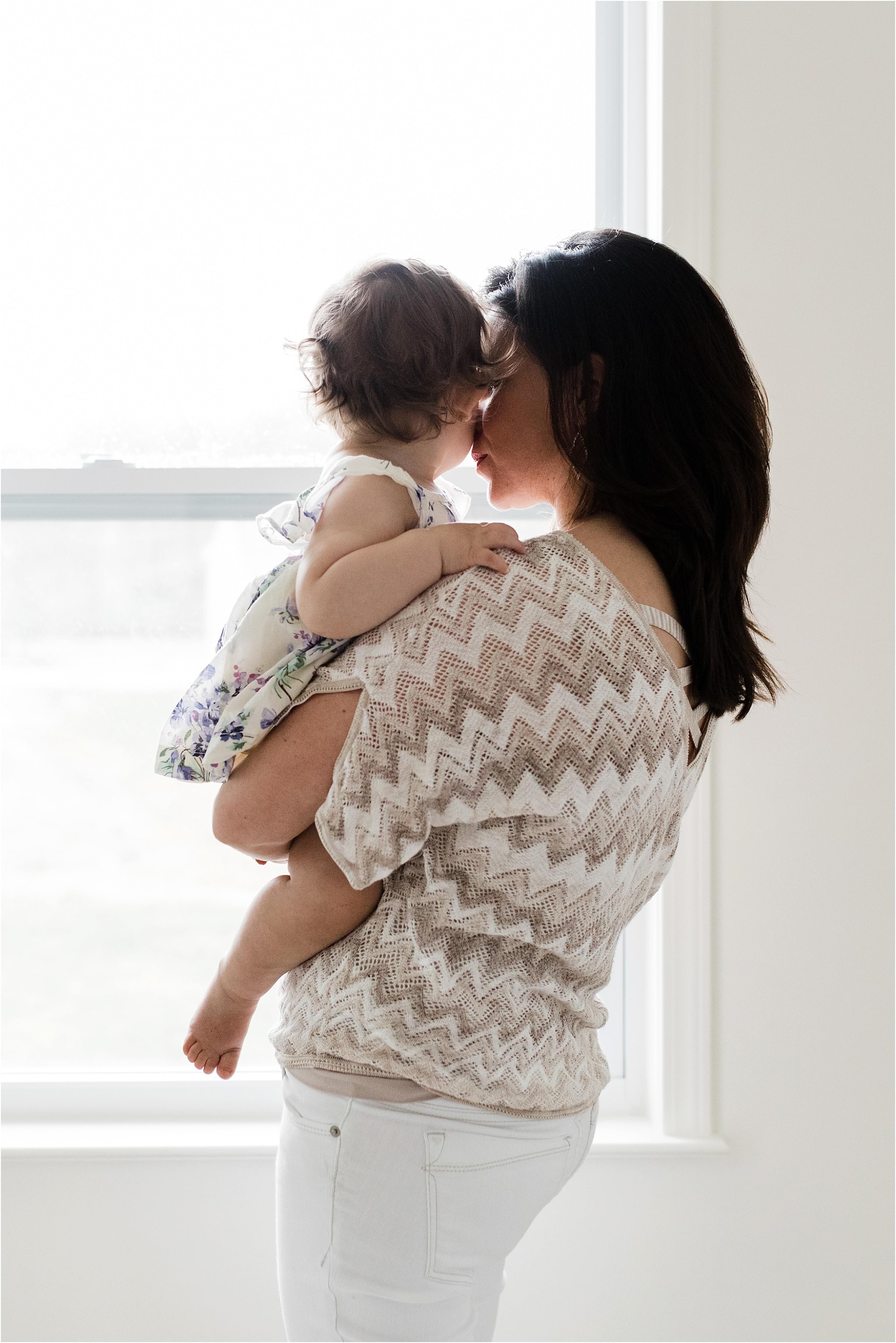 mother holding baby girl at home