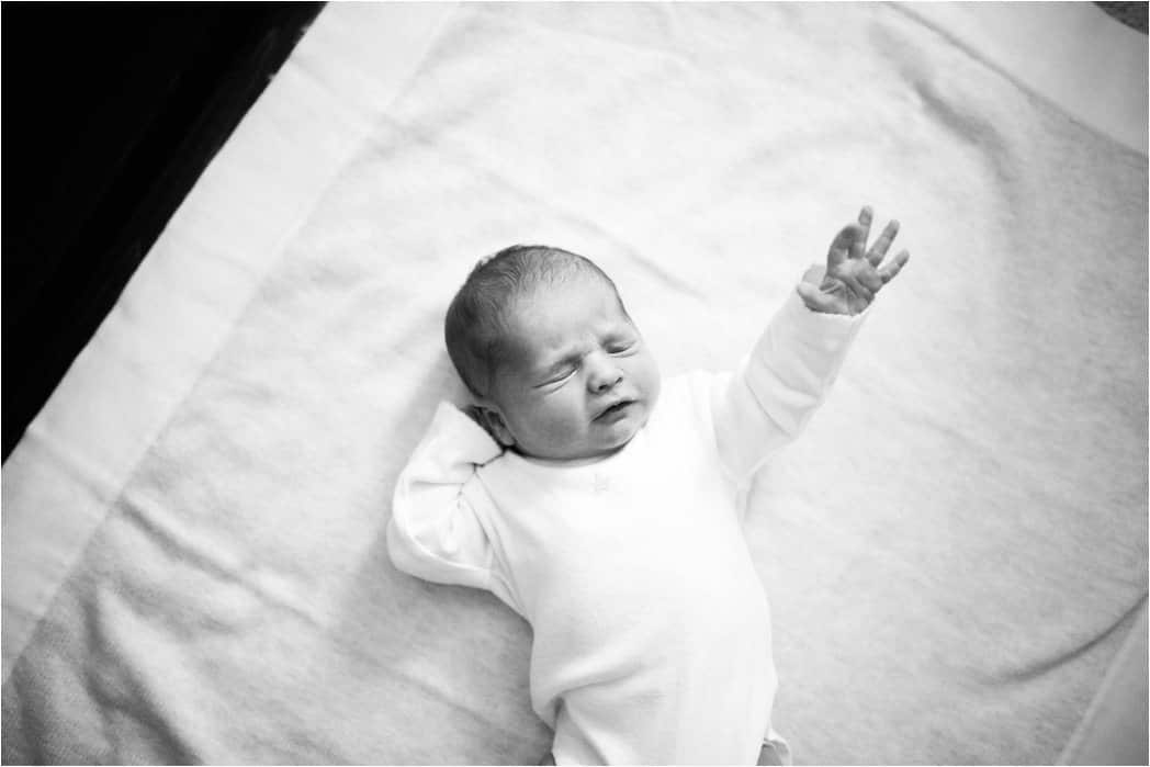 newborn baby stretching out on blanket