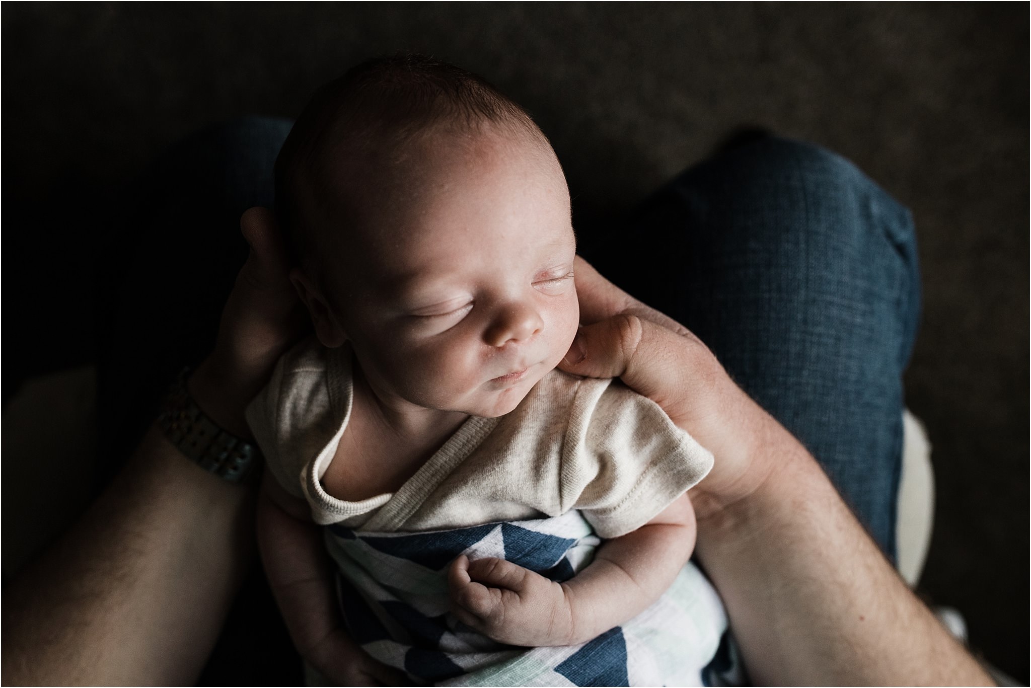 newborn boy held by father