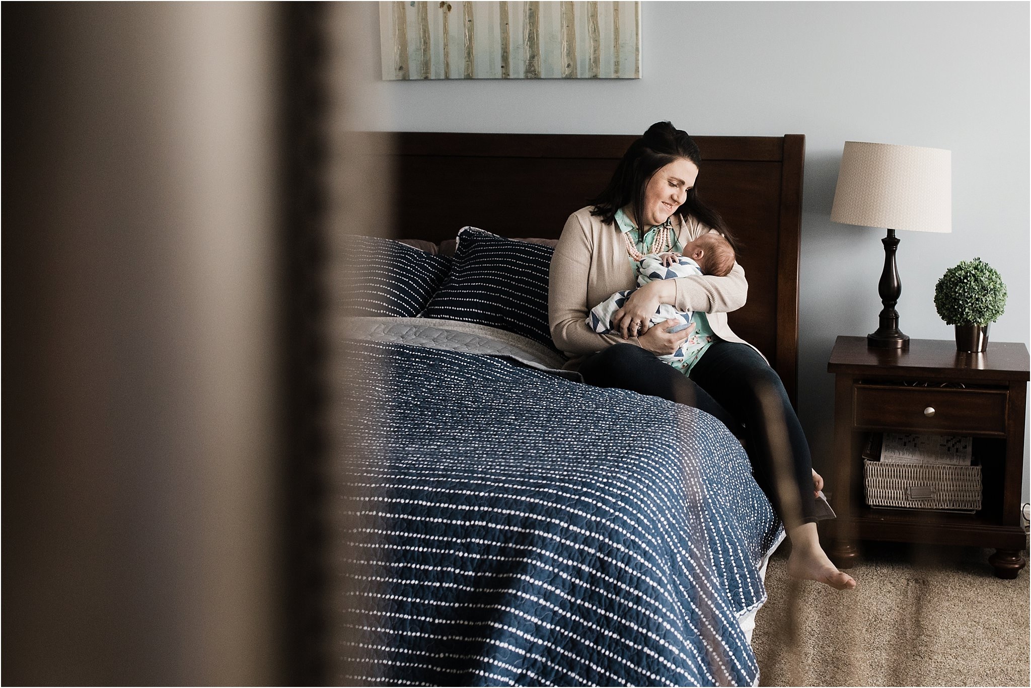 mother holding newborn baby on bed