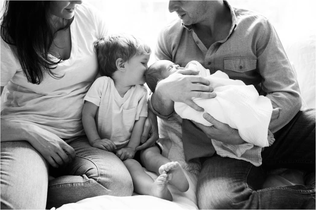 family loving newborn baby during home newborn session