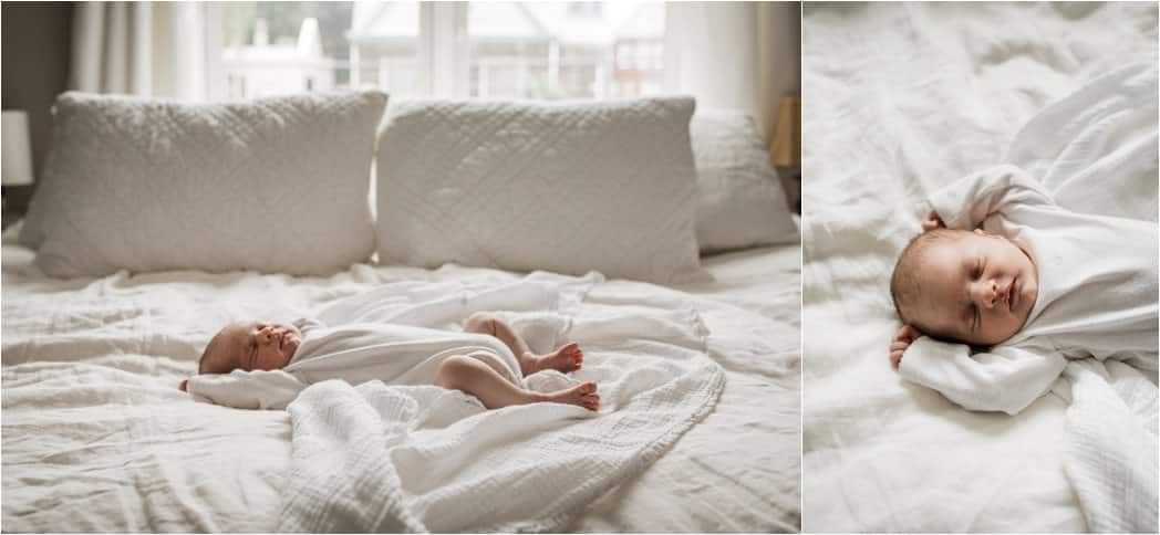 newborn in white onesie laying on a bed