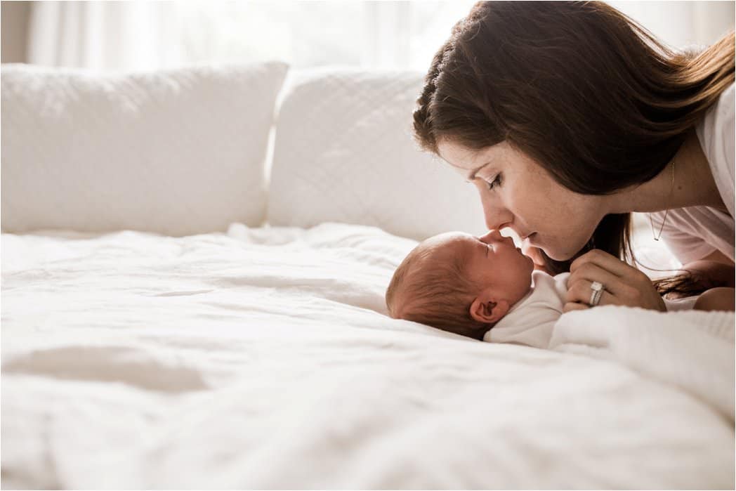 mother kissing newborn baby 