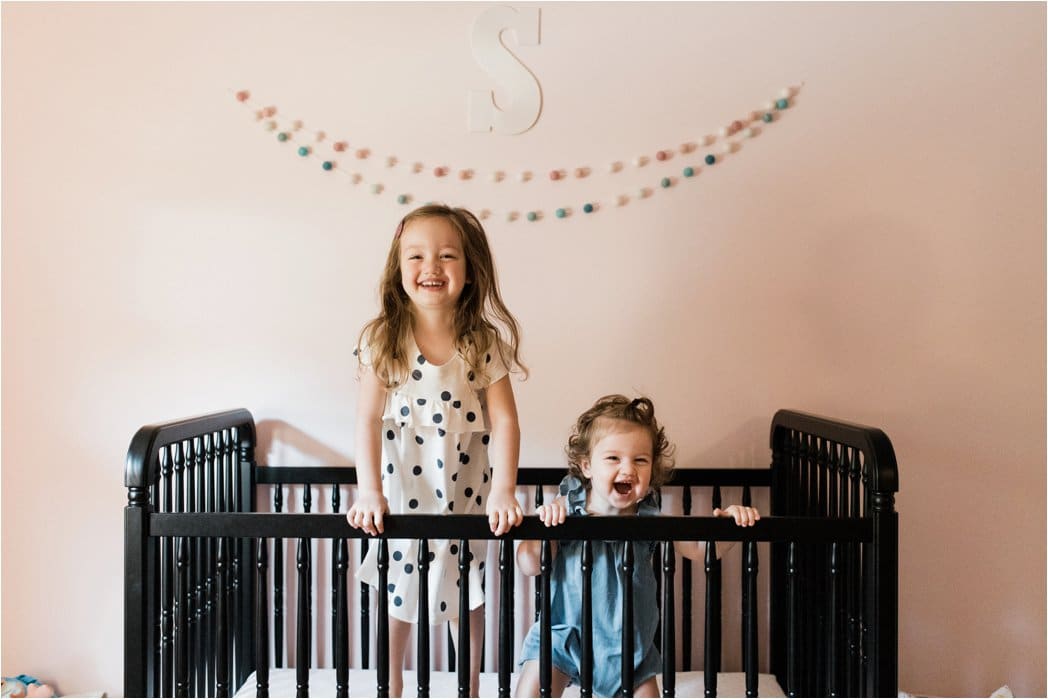 sisters being playful in crib 