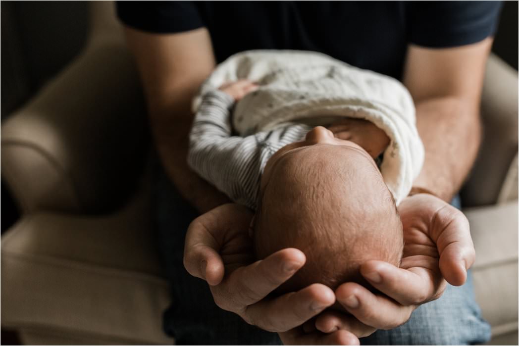 newborn baby in fathers hands