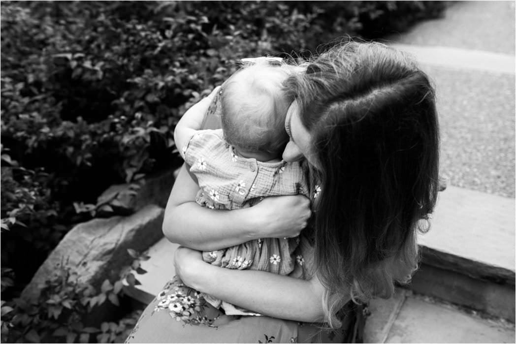 MOTHER HUGGING ONE YEAR OLD DAUGHTER