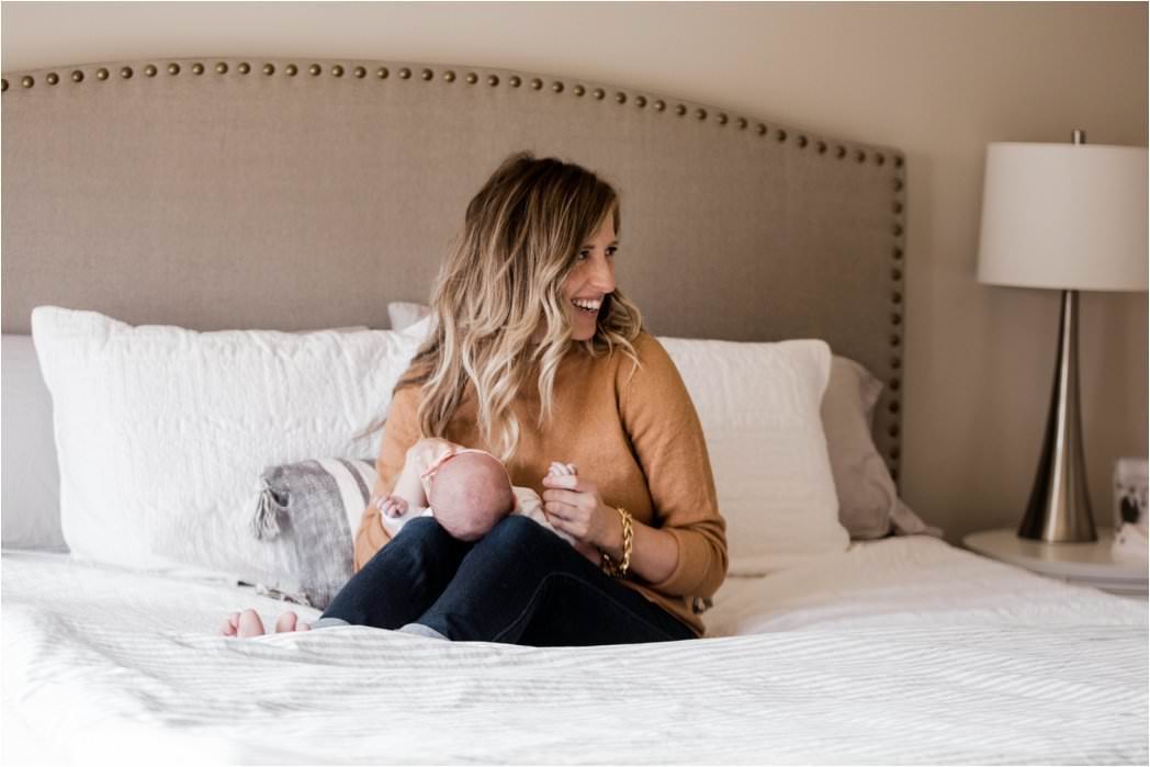 new mother laughing with baby at newborn photography session