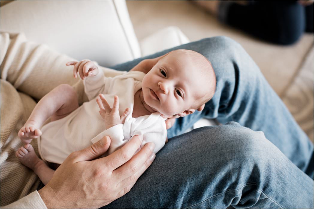 newborn baby girl in daddy's lap