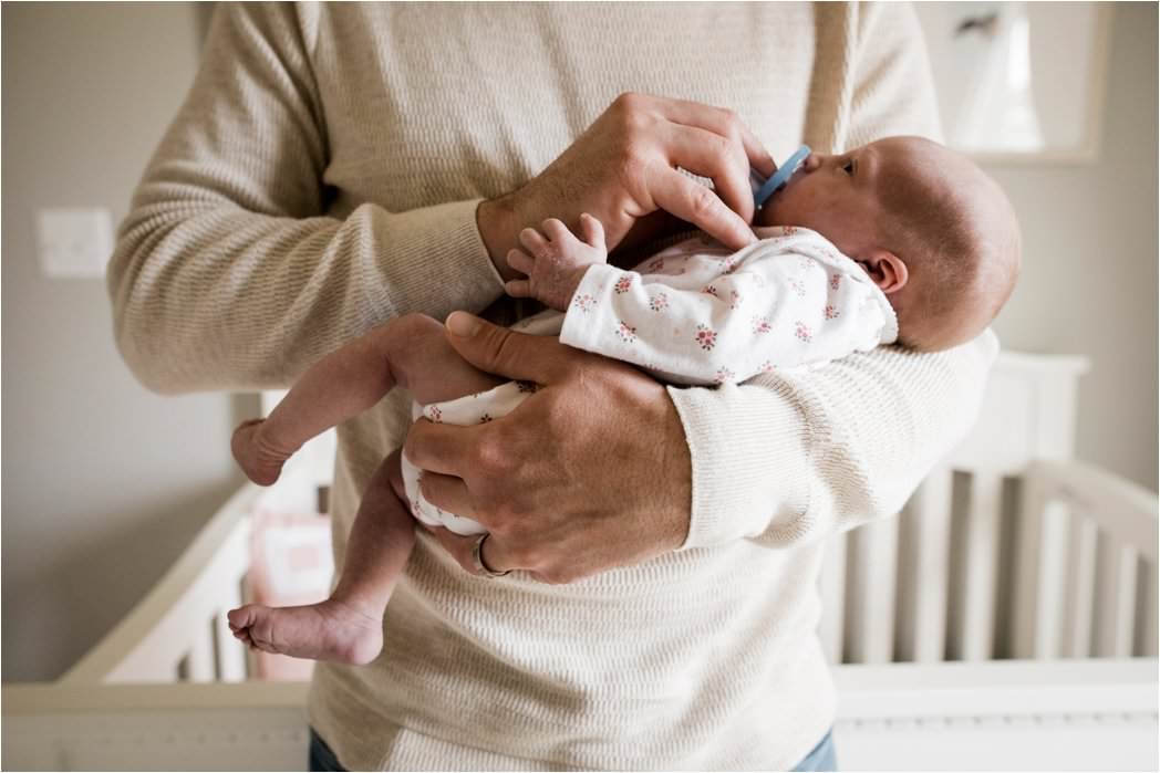 newborn baby girl in daddys arms