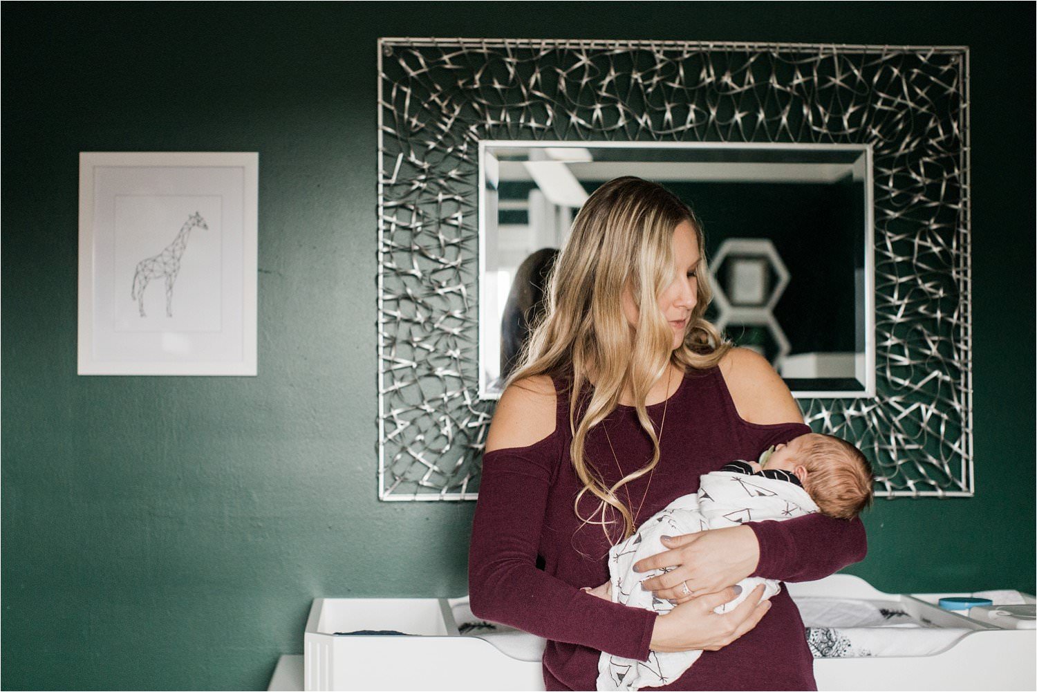 mother soothing newborn baby boy in home nursery