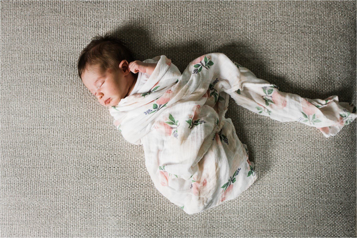 newborn baby girl in a floral swaddle