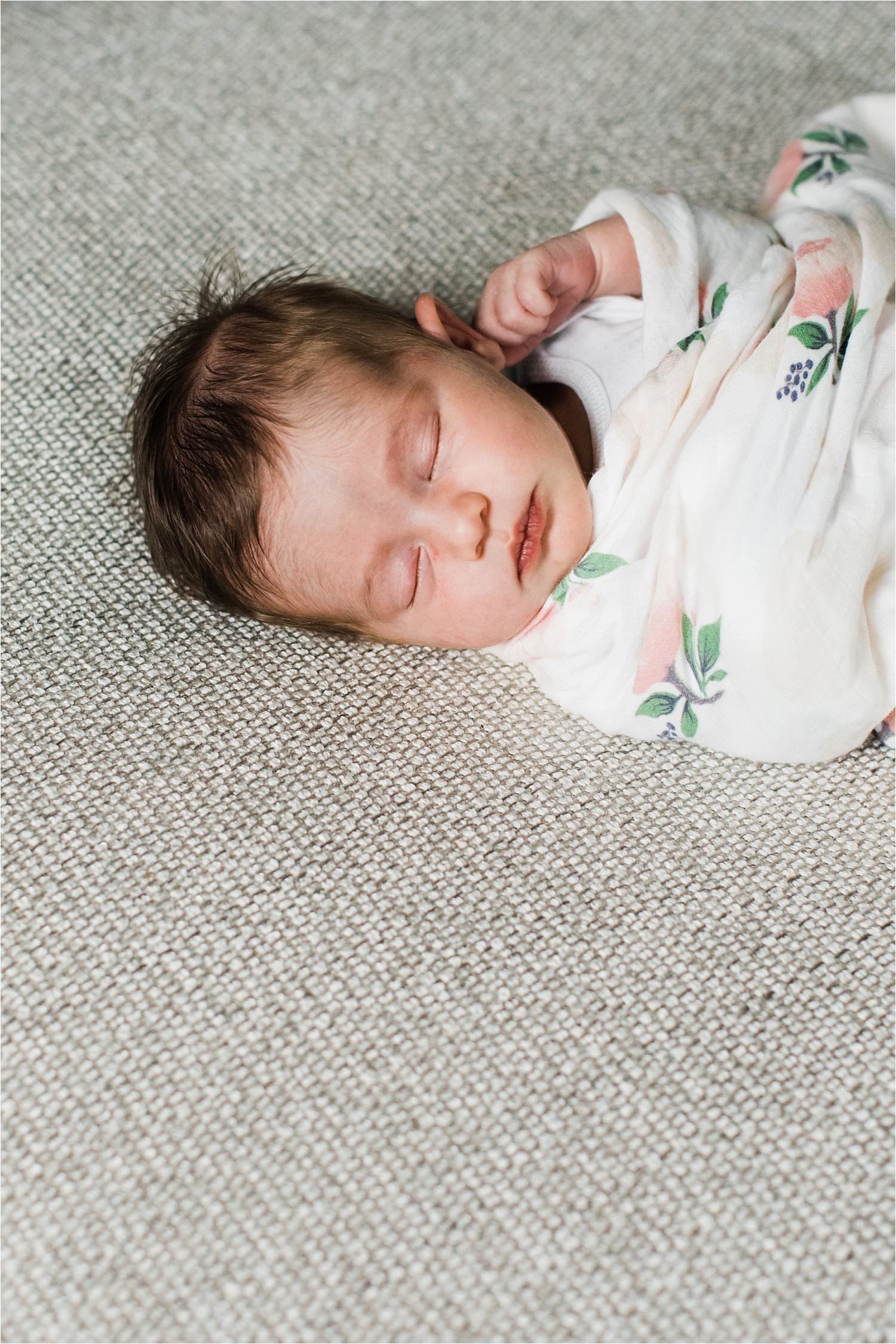 newborn baby sleeping in a floral swaddle