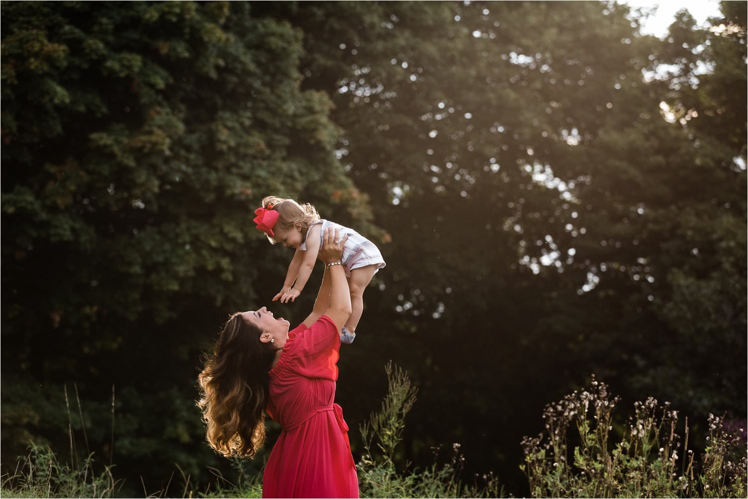 mother holding and dancing with daughter in open field in pittsburgh