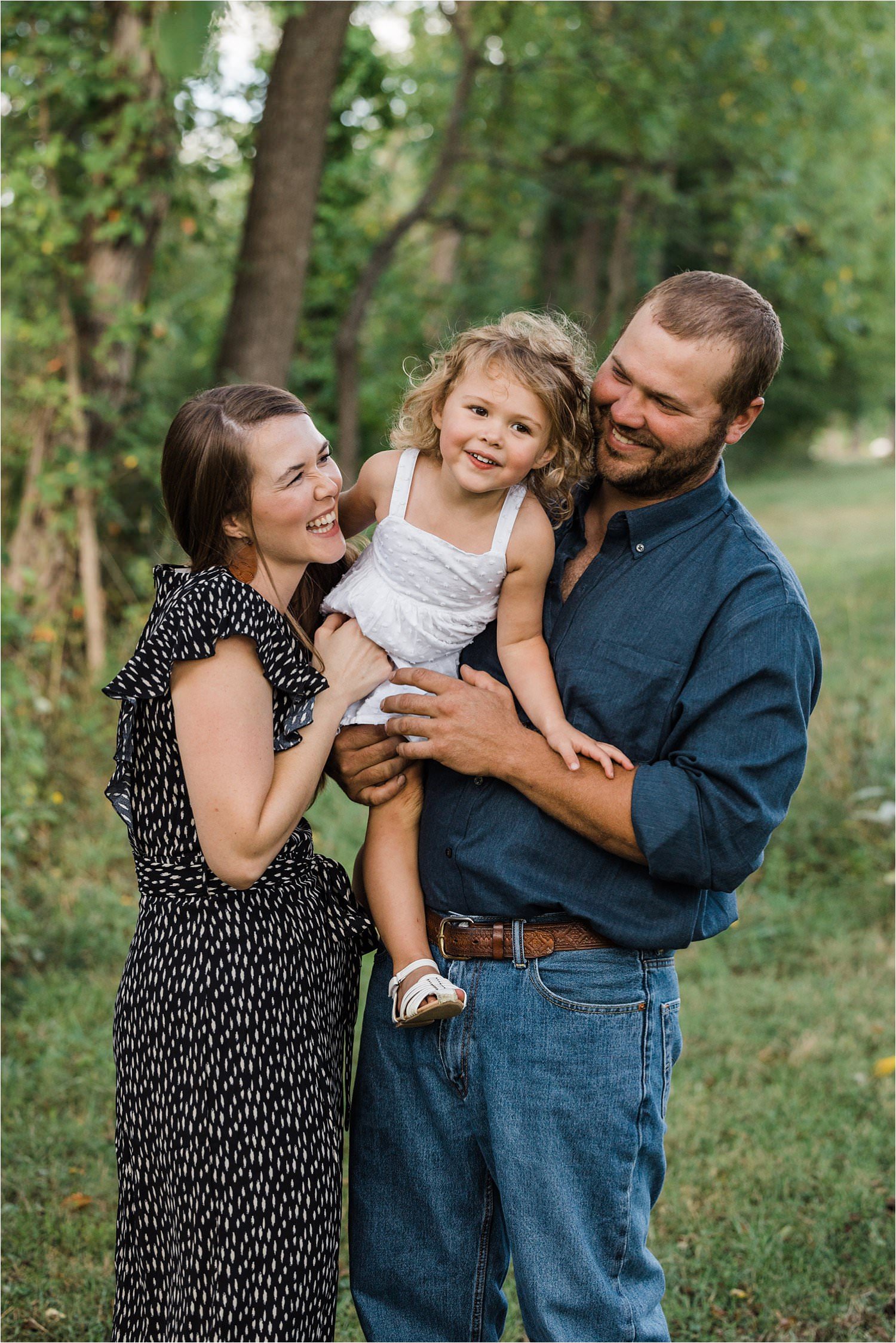 fun photo of parents holding their daughter