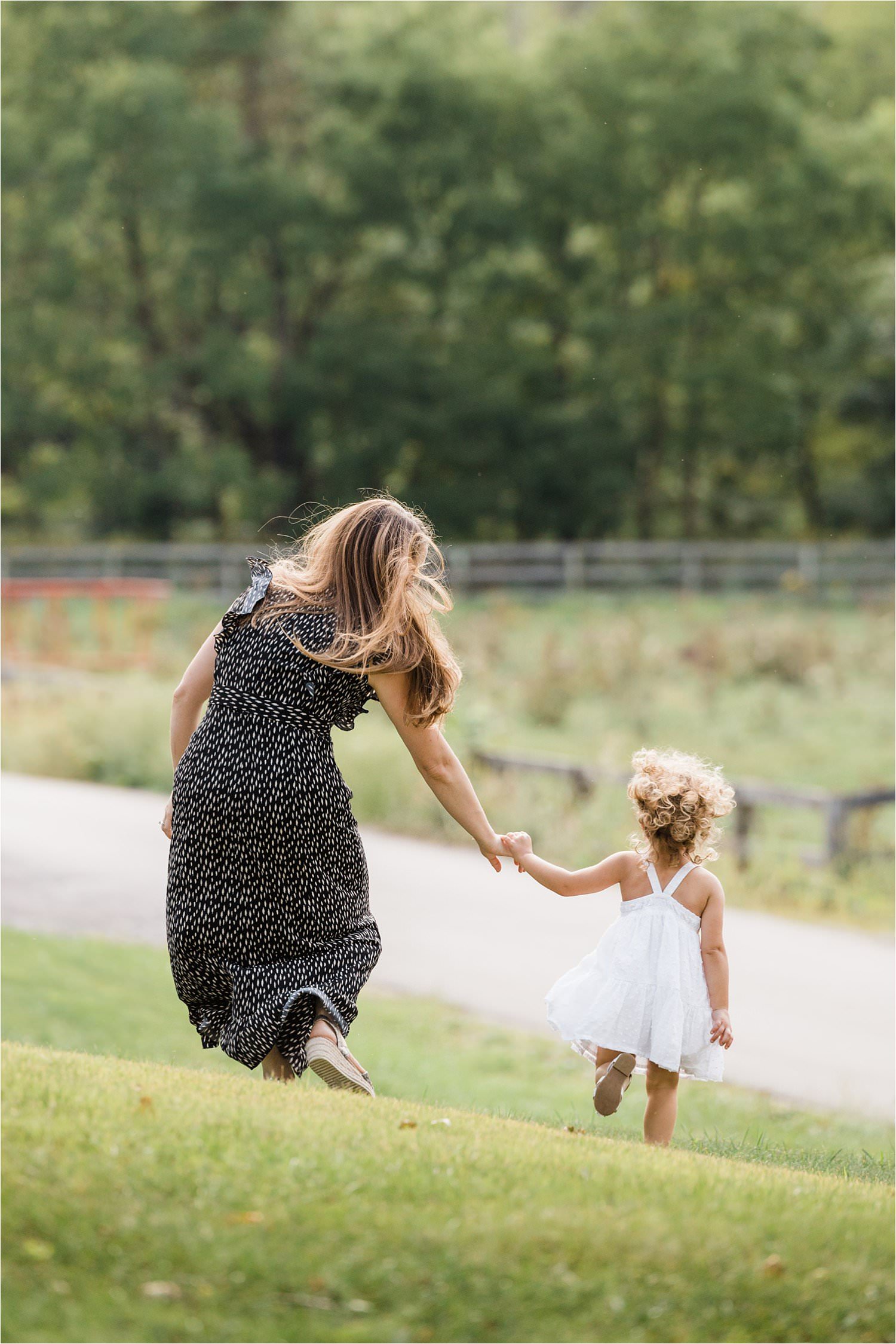 mama and little girl in dresses running and holding hands