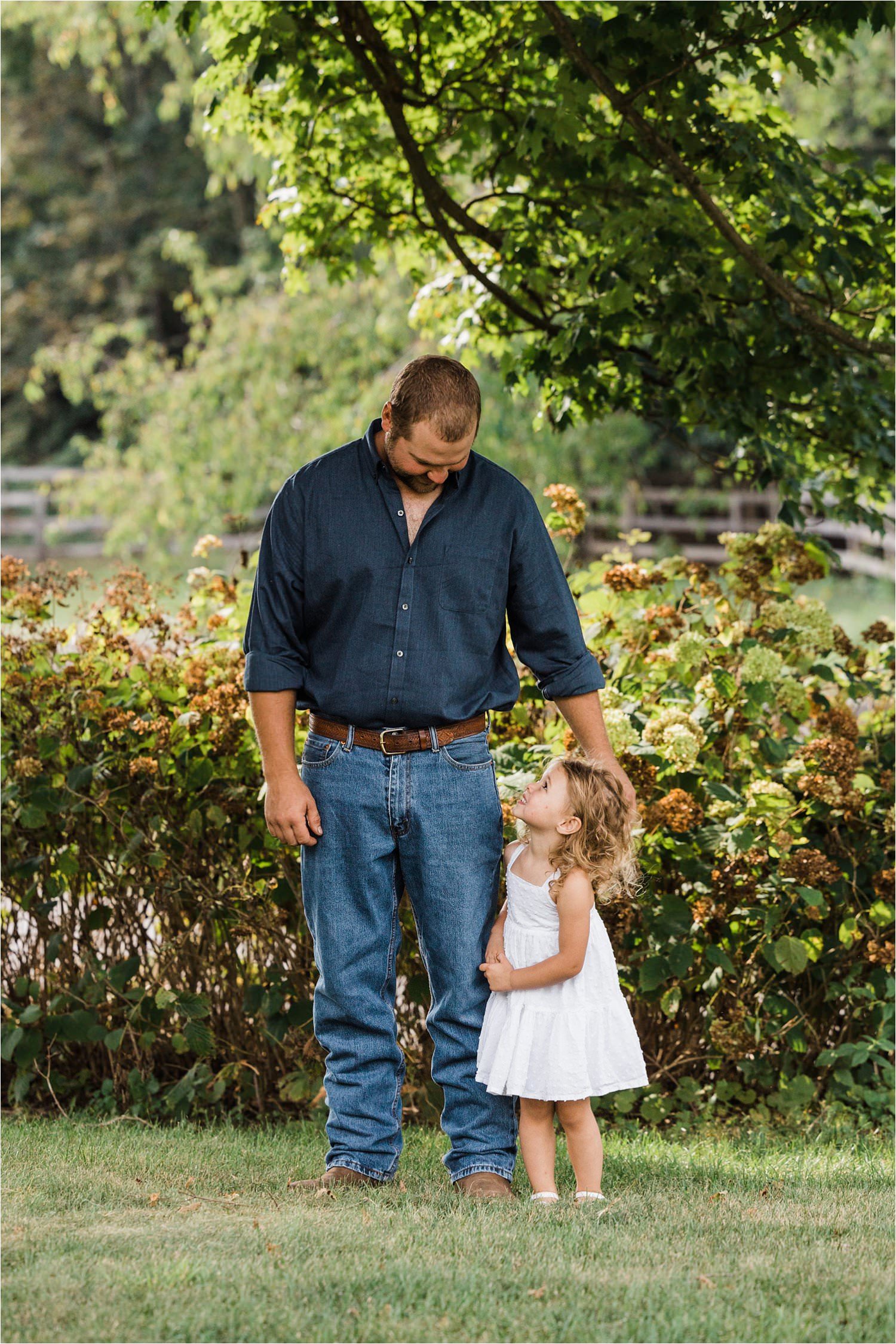 little girl in white dress looking up at her daddy