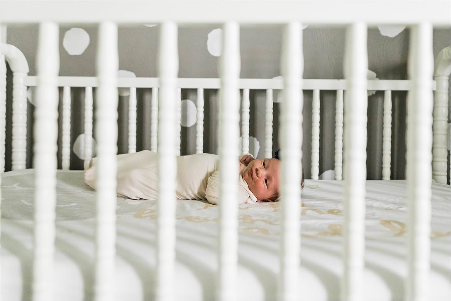 newborn baby laying in crib